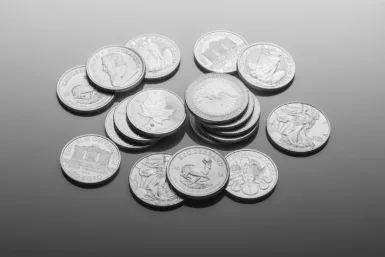 silver round coins on white surface