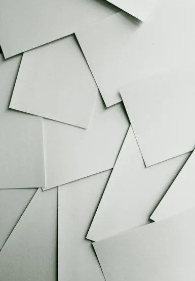 Scattered sheets of white paper covering the entire frame
