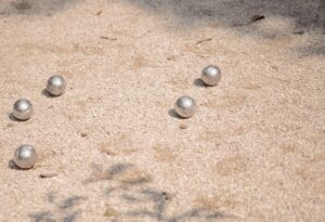 a group of balls sitting on top of a sandy ground