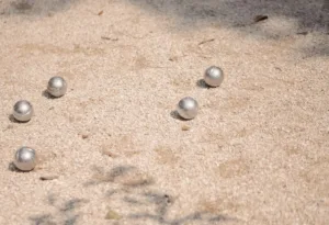 a group of balls sitting on top of a sandy ground